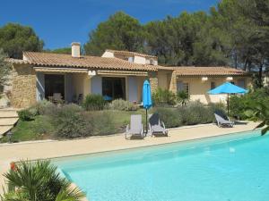 ein Haus mit einem Pool, 2 Stühlen und einem Sonnenschirm in der Unterkunft L'Oustau de Bigatié in Lambesc