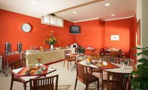 a restaurant with red walls and tables and chairs at Borgo San Martino in Bra