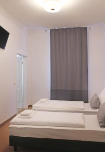 a hotel room with a white bed and white curtains at dingdong bonn - city apartments in Bonn