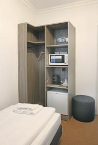 a small room with a bed and a television at dingdong bonn - city apartments in Bonn