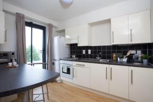 a kitchen with a stove top oven, sink and cabinets at Chalmers Street - The Meadows (Campus Accommodation) in Edinburgh