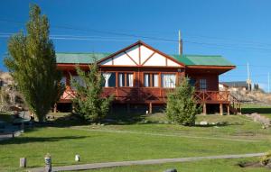 a large wooden house with a green roof at Cabañas Normana Inn in El Calafate