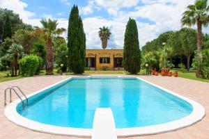 una piscina frente a una casa con árboles en Villa Delle Lantane, en Mesagne