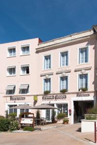 a large white building with a bench in front of it at Grand Hotel Pelisson in Nontron
