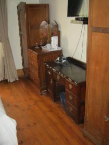 Habitación con escritorio de madera y cómoda. en Ladismith Manor, en Ladismith