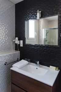 La salle de bains est pourvue d'un lavabo blanc et d'un miroir. dans l'établissement Grand Hotel Pelisson, à Nontron