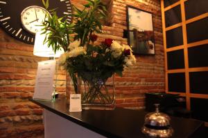 un vaso di fiori su un bancone con un orologio di Hôtel La Chartreuse a Tolosa