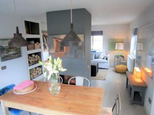 a living room with a vase of flowers on a table at Crown Cottage, Orford - Prime Orford Location in Orford +16 photos