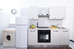 アトラーニにあるM.A.M.A Homeのキッチン(白いキャビネット、洗濯機、乾燥機付)
