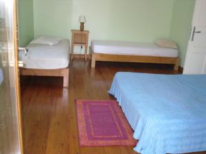 1 dormitorio con 2 camas y suelo de madera en Gîte-La Combelle, en Dornas