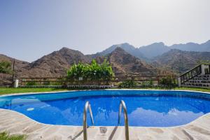 a swimming pool with mountains in the background at Apartamentos Los Telares in Hermigua