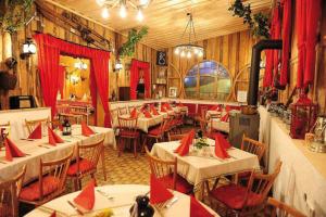 un ristorante con tavoli e sedie con tovaglioli rossi di Cafe Rundblick a Baiersbronn