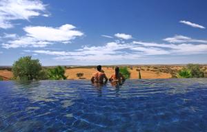 two people standing in the water in a swimming pool at Vale Do Manantio in Moura