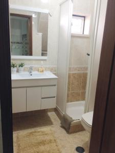 a bathroom with a sink and a shower and a toilet at Casa BeijoMar in Nazaré