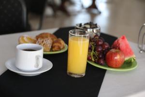 bandeja de desayuno con un vaso de zumo de naranja y un plato de fruta en Hotel Bulevar, en Paysandú