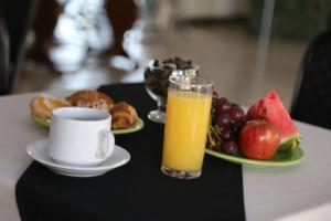 un vaso de zumo de naranja junto a un plato de fruta en Hotel Bulevar, en Paysandú