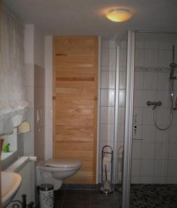 路德斯塔德艾斯勒本的住宿－Ferienhaus Hofmann，一间带卫生间和木门的浴室