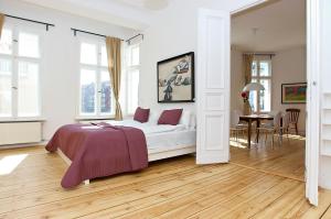 een witte slaapkamer met een bed en een eetkamer bij Apartment Prenzlauer Allee in Berlijn