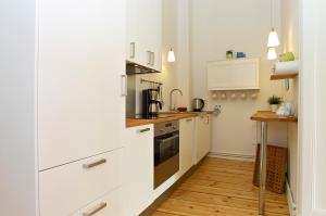 een keuken met witte apparatuur en een houten vloer bij Apartment Prenzlauer Allee in Berlijn