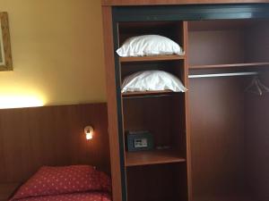 twee witte kussens op een boekenplank in een slaapkamer bij Hotel De Venne in Genk