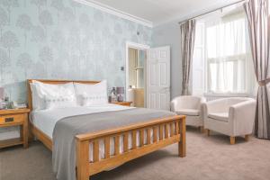 a bedroom with a bed and a chair at Lauriston Hotel in Weston-super-Mare