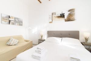 una camera bianca con un letto e un divano di White terrace apartment navona a Roma