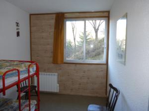ein Schlafzimmer mit einem Fenster und einem Etagenbett in der Unterkunft GRANDE CHAUME A 42 in Le Sauze