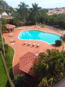 uma grande piscina com cadeiras e guarda-sóis em Bekassin Botucatu Hotéis Ltda em Botucatu