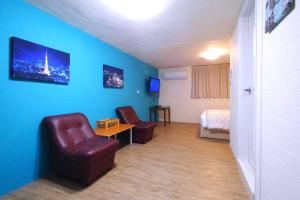 a room with a couch and a chair and a bed at Traveler Station in Kaohsiung