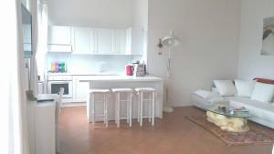 uma cozinha e sala de estar com um sofá e uma mesa em Appartamento Ellen em Nago-Torbole