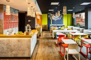 a restaurant with tables and chairs in a cafeteria at ibis budget London Hounslow in Hounslow