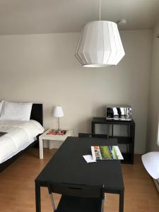 1 dormitorio con mesa negra, cama y lámpara en Maison Chez Laurent, en Baie-Saint-Paul