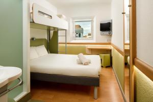 a small room with a bed and a window at ibis budget London Hounslow in Hounslow