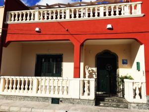 Casa roja y blanca con balcón blanco en B&B Casa Alba Salentina, en Porto Cesareo