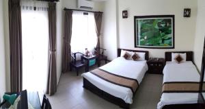 Habitación de hotel con 2 camas y ventana en Tran Ly Hotel, en Hue