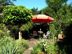 a patio with a table and an umbrella in a garden at Overbosch in Bilthoven