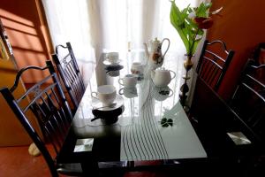 stół z kubkami i wazami na górze w obiekcie Sa Rest Inn w mieście Haputale