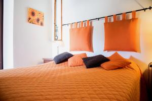 una cama naranja con almohadas naranjas encima en Olive Tree Hill, en Zagarolo