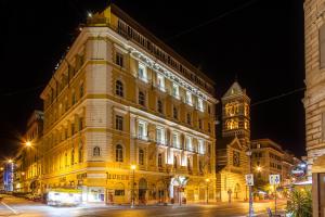 a large building with a clock tower at night at La Griffe Hotel Roma in Rome