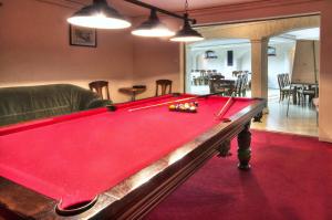 a red pool table in a living room at Hotel Habenda in Krutyń