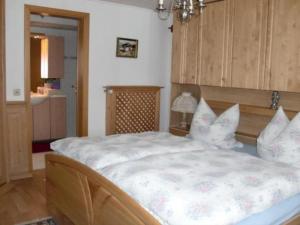 a bedroom with a large white bed with pillows at Ferienalm in Ruhpolding