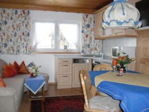 a kitchen with a table and a couch in a room at Ferienalm in Ruhpolding