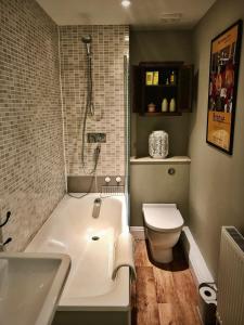 a bathroom with a white tub and a toilet at Flat 4, York Terrace in Norwich