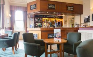 a bar in a pub with chairs and a table at Lauriston Hotel in Weston-super-Mare