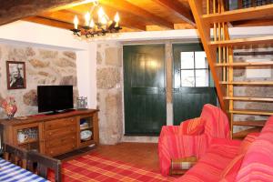 ein Wohnzimmer mit roten Stühlen und einem TV in der Unterkunft Casa d'avó Maria in Seia