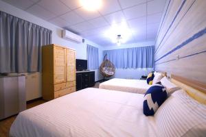 a hotel room with two beds and a television at Traveler Station in Kaohsiung