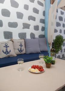 a table with a plate of food and two glasses of wine at Lampi's House in Patmos