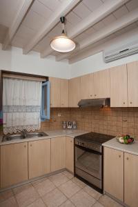 a kitchen with wooden cabinets and a stove top oven at Lampi's House in Patmos