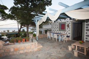 a patio with a table and chairs and a building at Lampi's House in Patmos