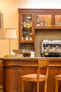 a bar with two chairs and a table with a lamp at Hotel Traiano in Civitavecchia
